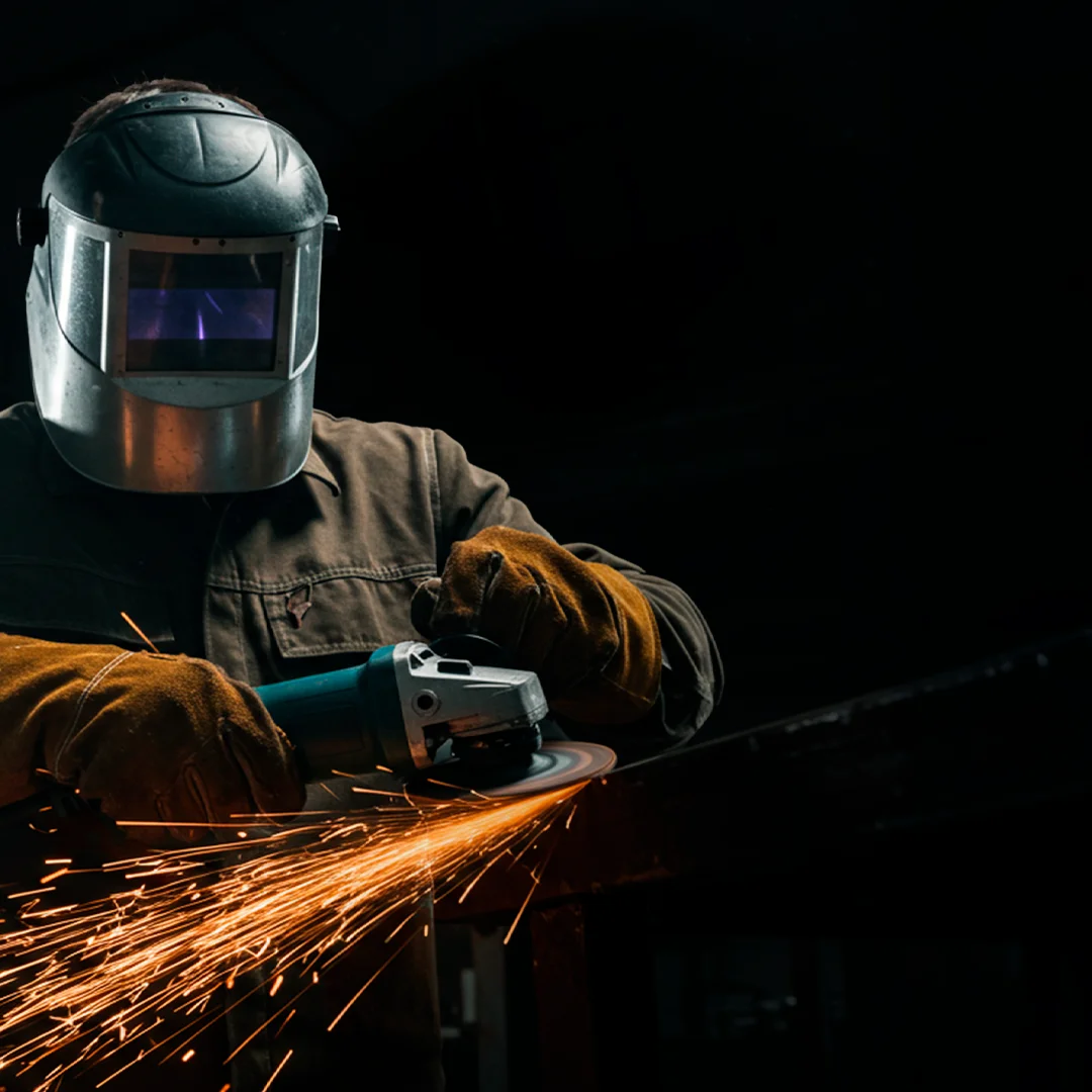 Serralheiro profissional utilizando equipamentos e ferramentas em sua oficina, representando o Mês do Serralheiro Minas Ferramentas.